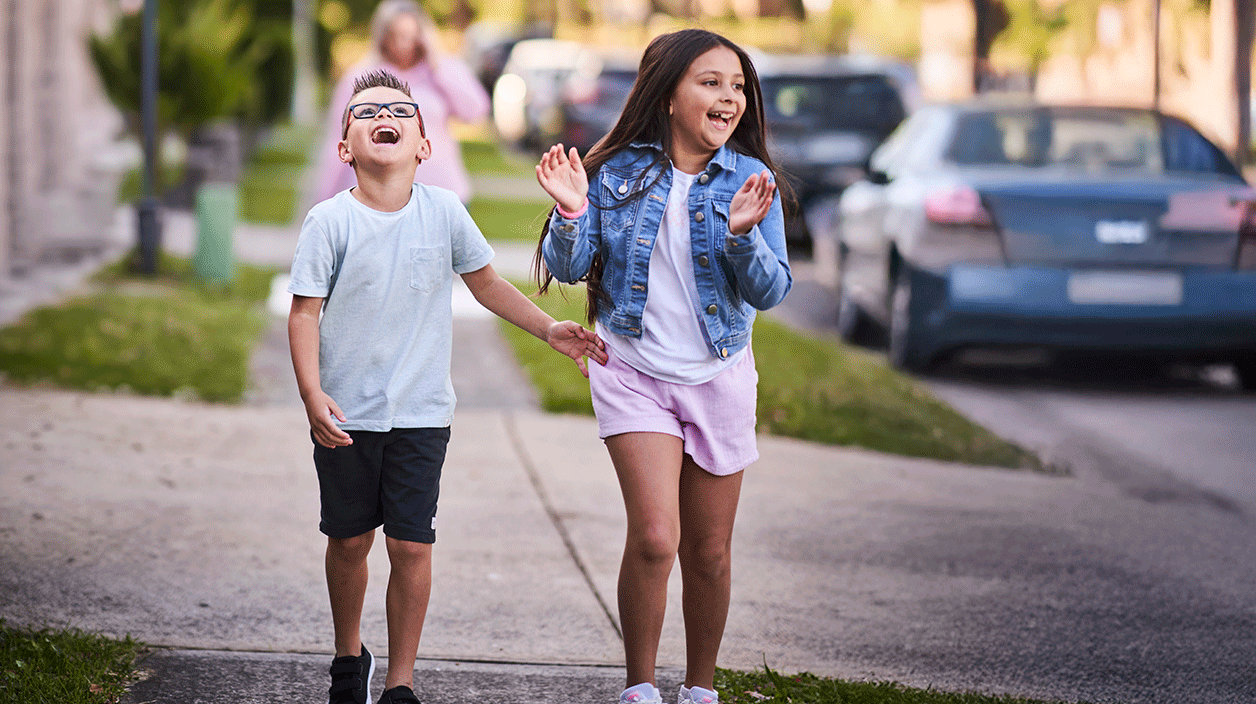 young boy and girl walking down a street