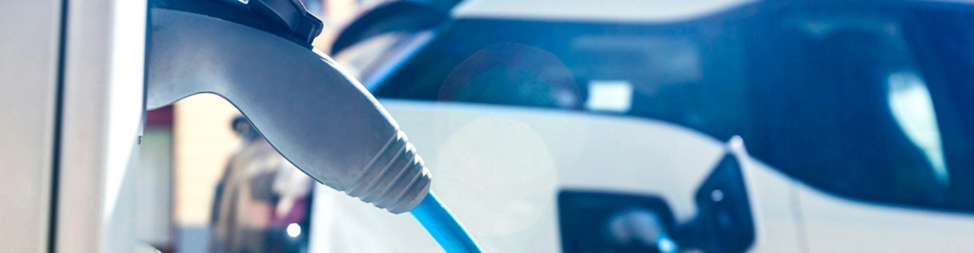 Side view of an electric vehicle charging cable plugged into a car.