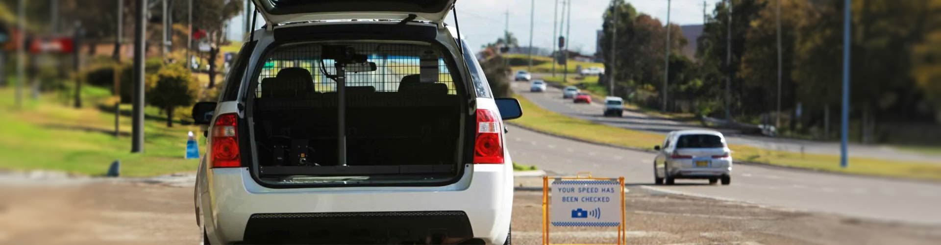 Car parked by side of road checking speed with camera in back of car 