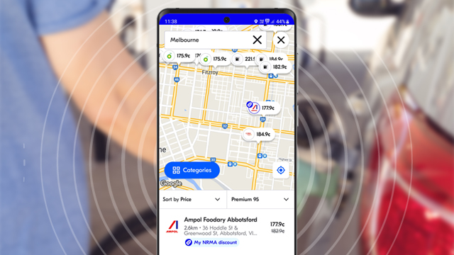 image of mobile phone with fuel app open in foreground with blurred image of person filling up their car with petrol in the background
