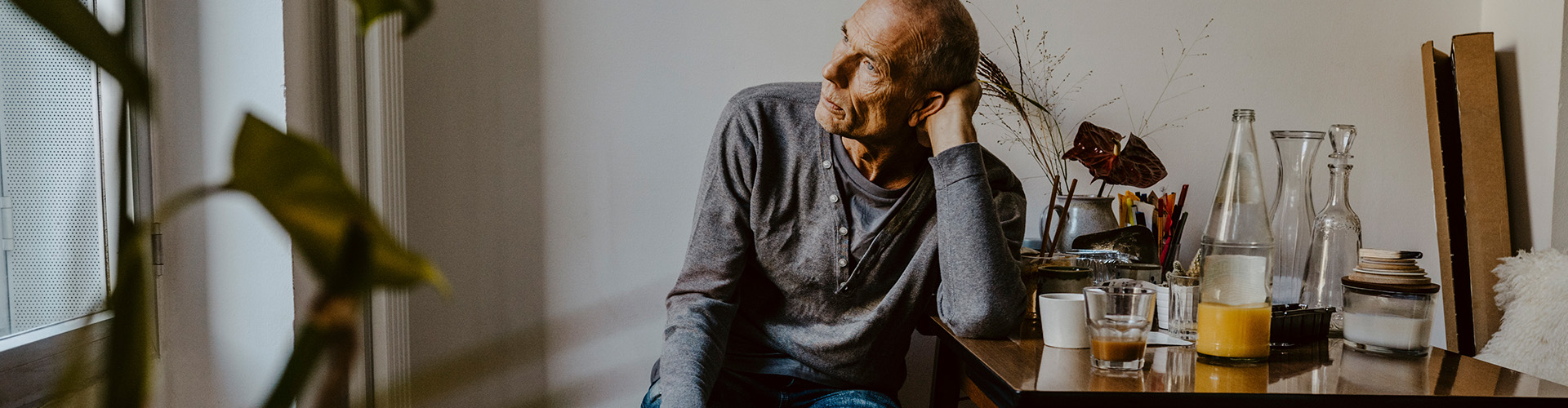 An older man sits alone at a table