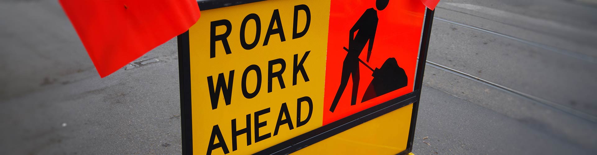 Yellow road work sign on a road