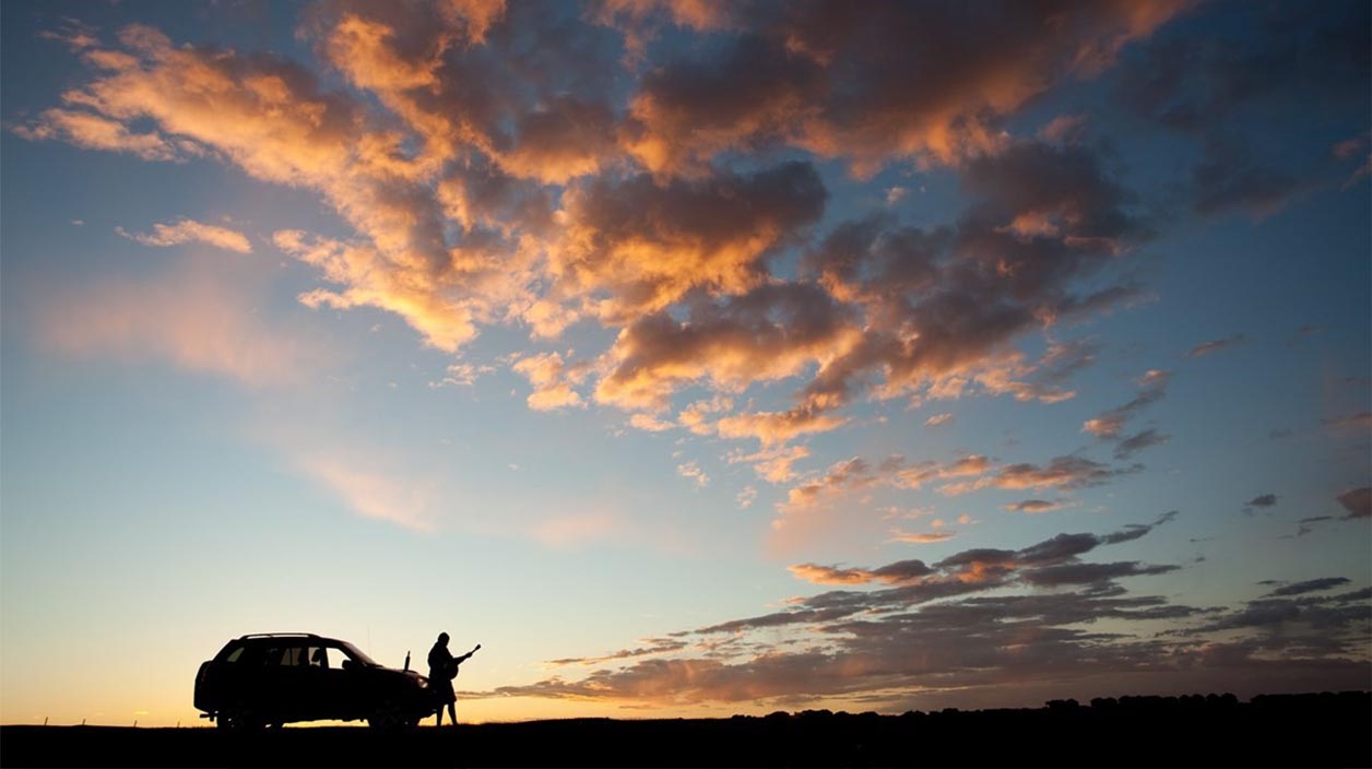 Silhouette of Man Playing Guitar Standing Beside Car Member who passed