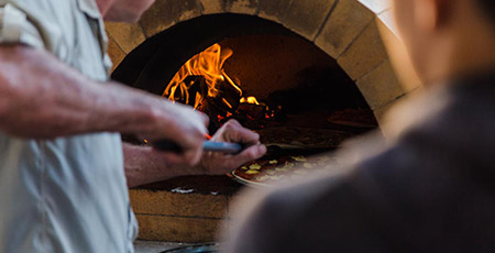 Wood-fired pizza oven cooking
