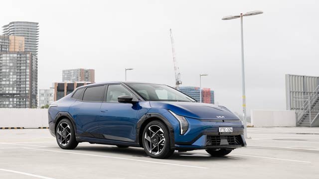 Side view pf a blue Kia EV4 electric car parked in a carpark