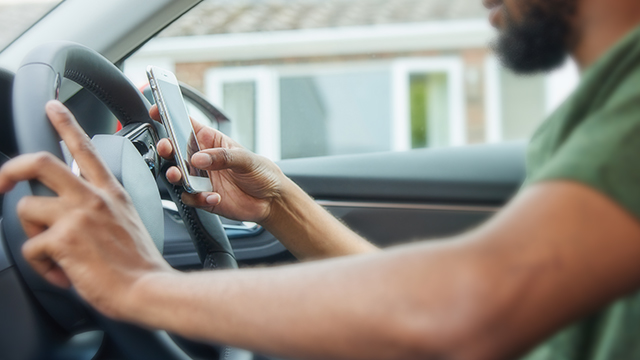 Holding a mobile phone while driving