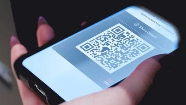 Hand holding phone with qr code showing