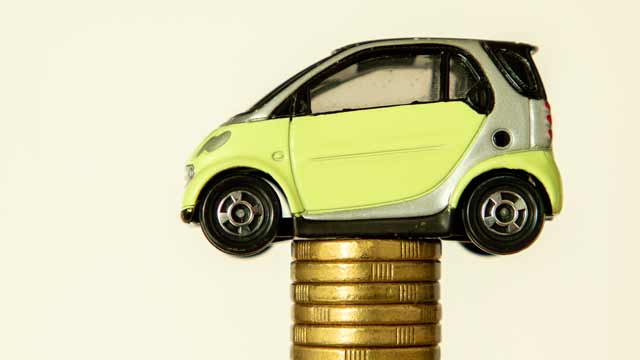 Small yellow toy car on stack of $2 coins