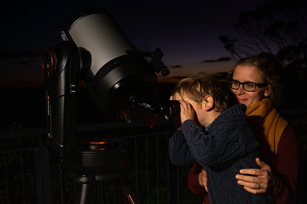 A child looking through a telescope