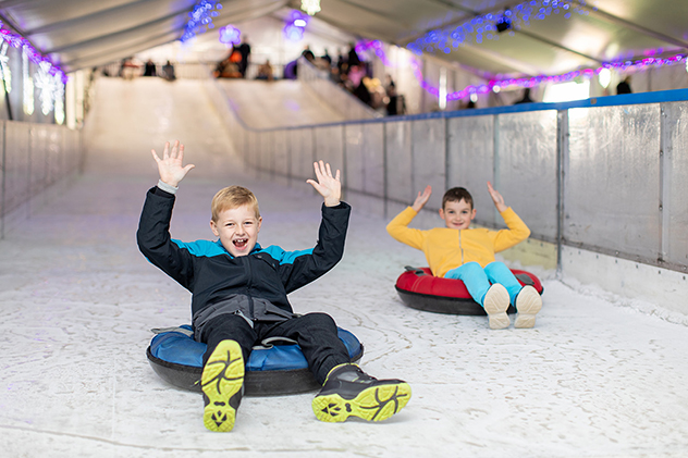 Children sliding on snow indoors