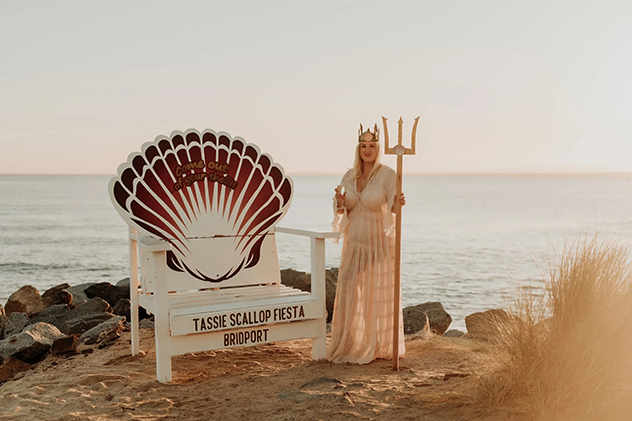 A woman holding a trident near a throne
