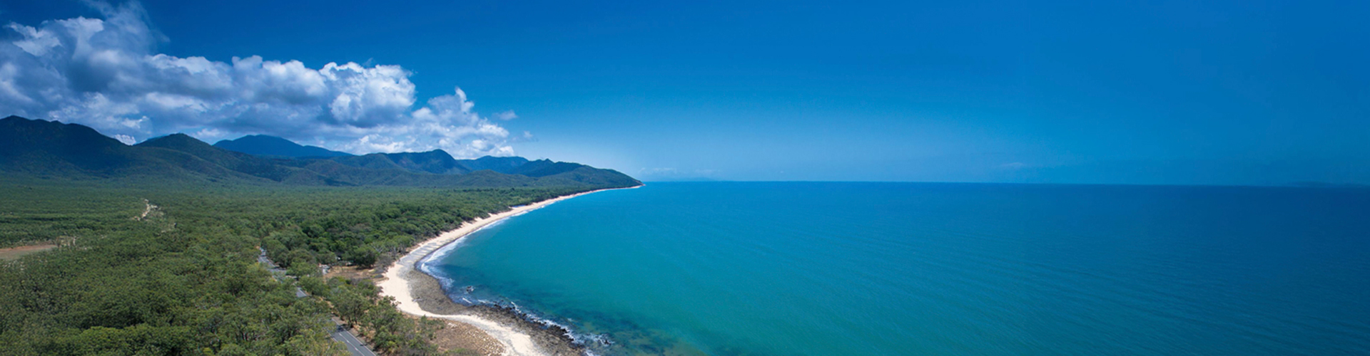 A road by an ocean with clouds