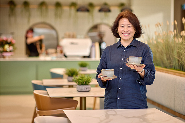 Woman holding coffee cups at Serenity Corner Cafe at Bernborough Ascot