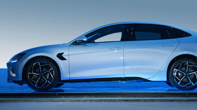 Side view of a light blue 2023 BYD Seal, parked on a dark blue platform.