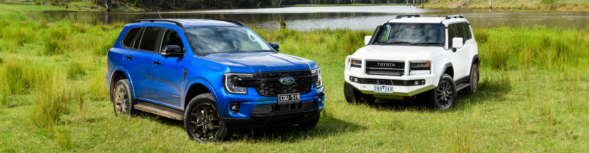 2025 Toyota Prado and Ford Everest parked in front of a lake