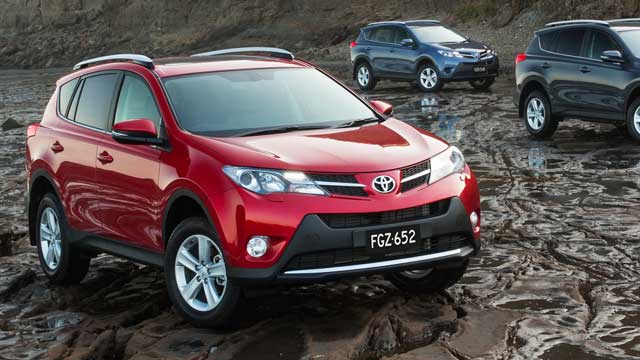 Red Toyota RAV4 parked in mud