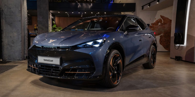 A dark blue 2024 Cupra Tascavan sits parked in a showroom