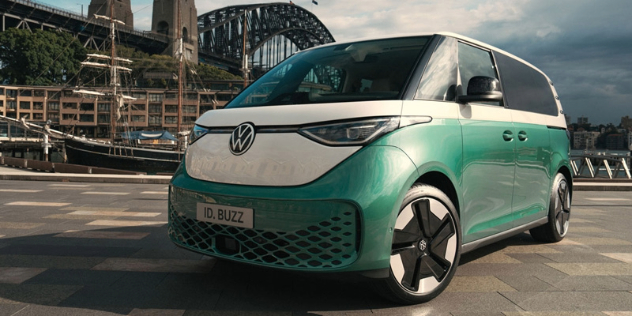 A green and white 2024 Volkswagen ID.Buzz sits in the sun in front of the Sydney Harbour Bridge