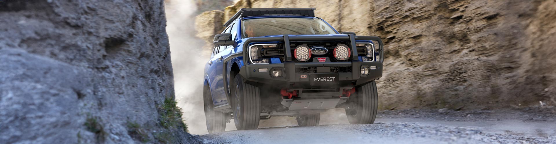 A ute with bull bars on the front drives through a rocky chasm