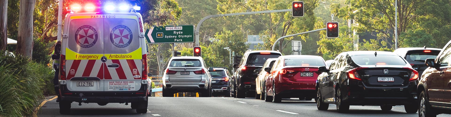 An ambulance is stopped by the side of road during peak hour