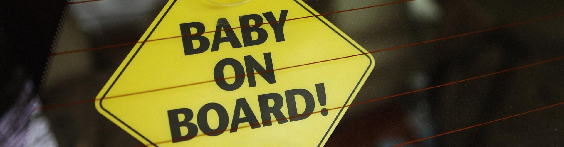 Closeup shot of baby on board sign in car behind back window