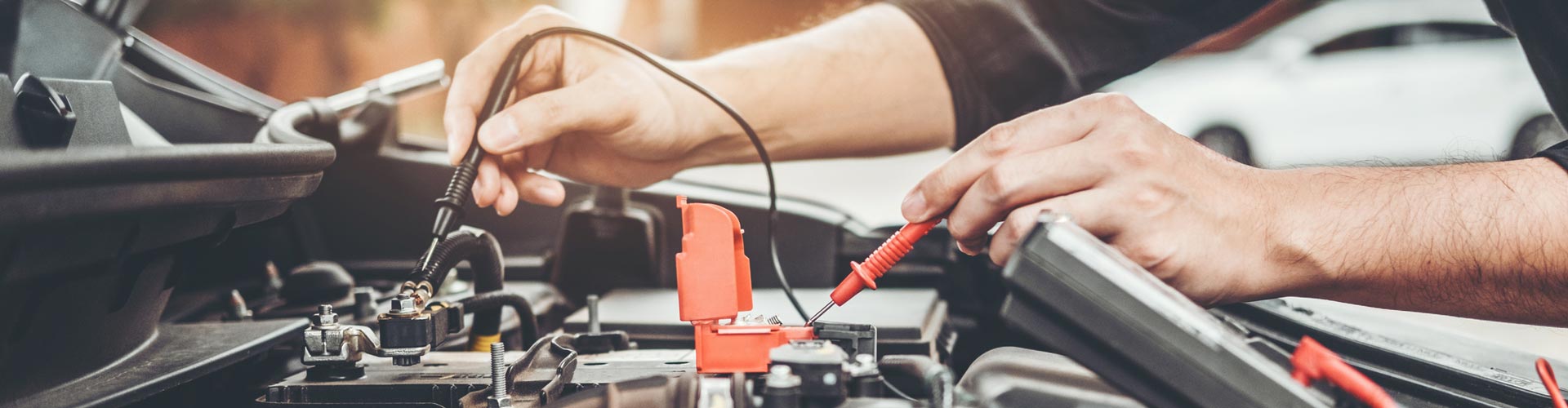 two hands testing a battery with instruments