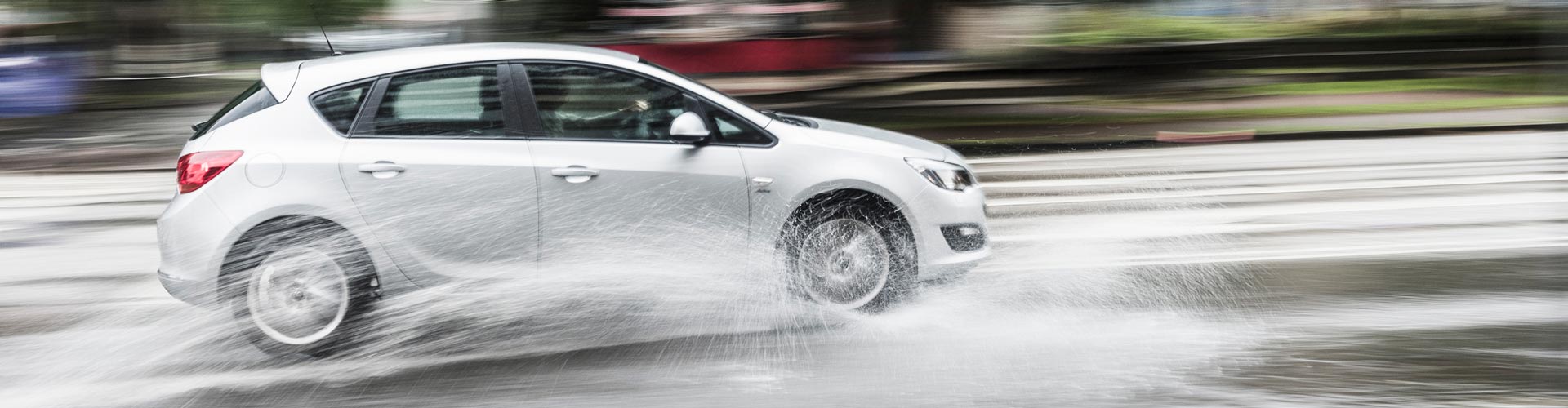 Car driving on a wet road at high speed