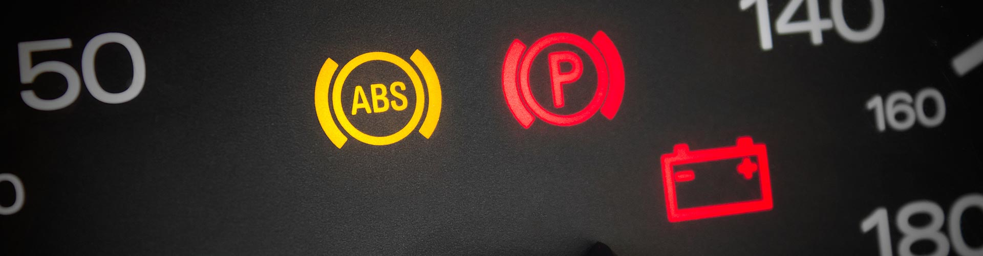 Closeup of three dashboard warning lights