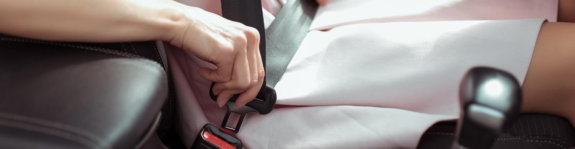 Person in school dress puts on a seatbelt