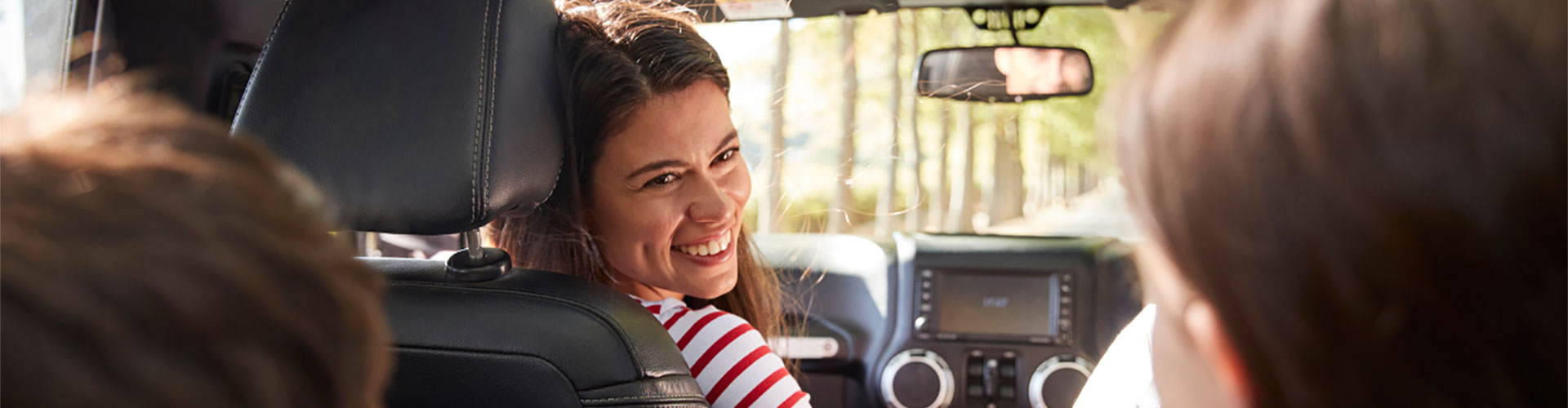 Content mum checking on her kids in backseat