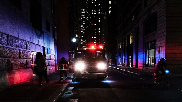 An emergency vehicle driving through city streets at night