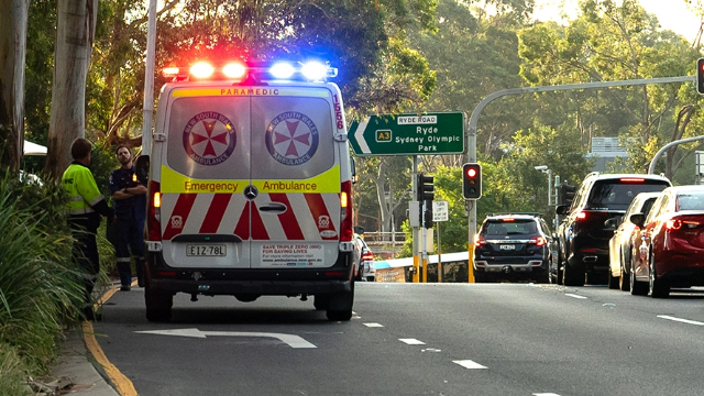 Ambulance with lights flashing stopped at a roadside emergency