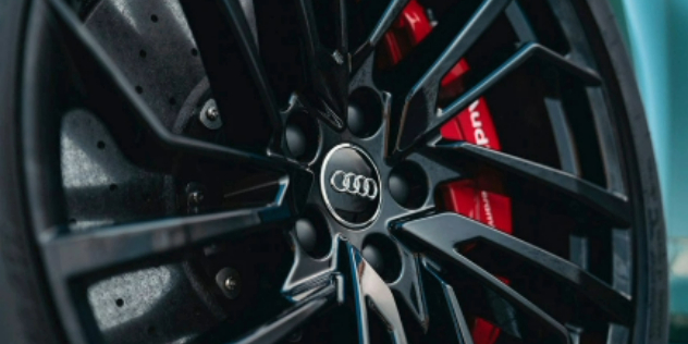 Angled view of a tyre with sporty red brake pads.