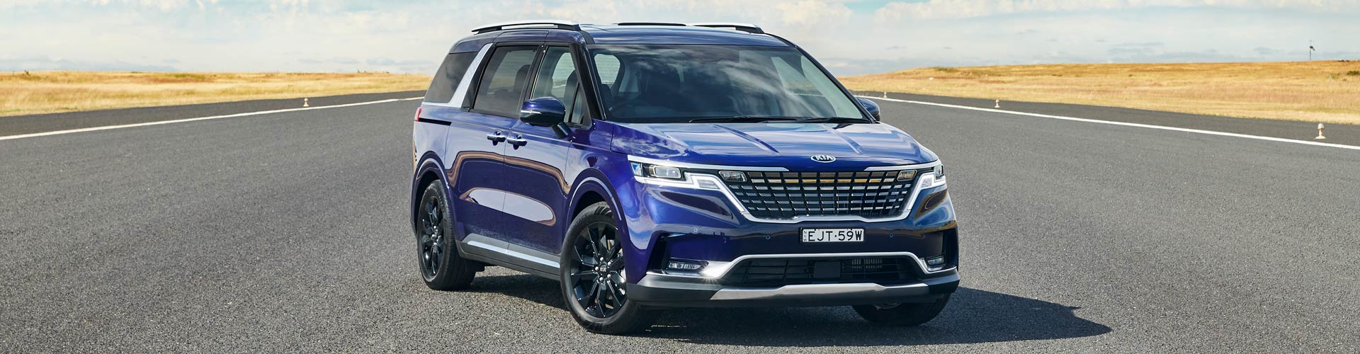 Blue 2021 Kia Carnival parked in middle of wide road