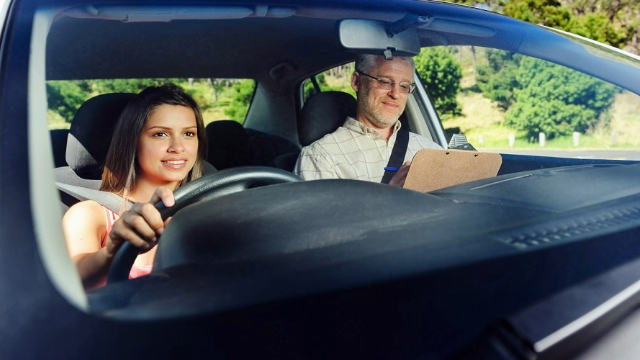 Woman learning to drive beside a driving instructor