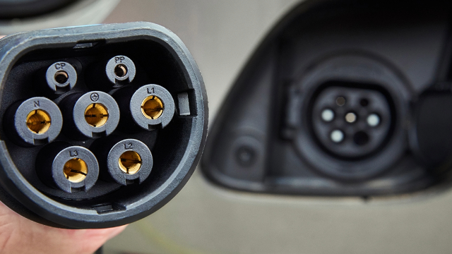 The end of an EV plug with the socket seen in the background