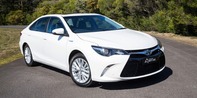 A white Toyota Camry hybrid parked 