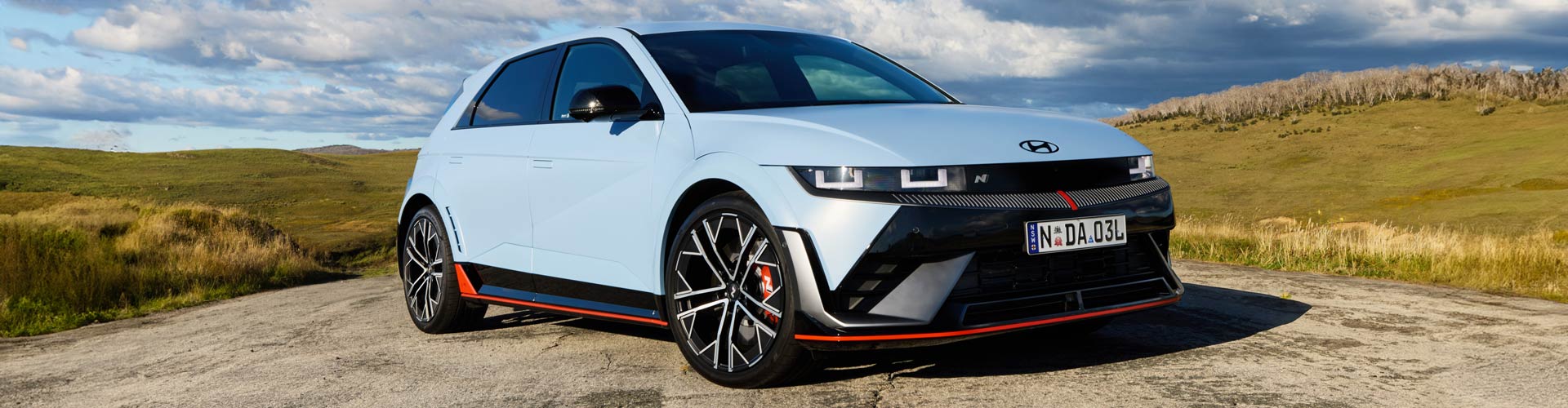 Blue 2024 Hyundai Ioniq 5 N driving on a road in the country