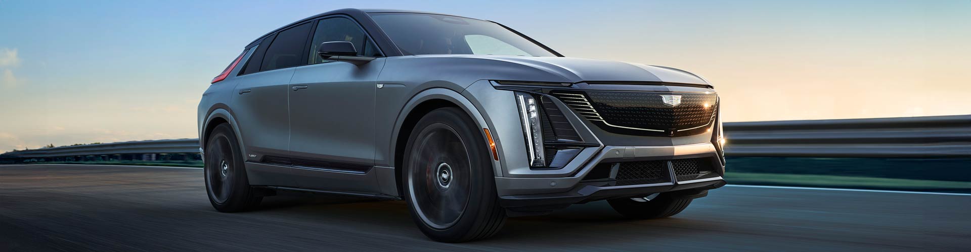 Silver Cadillac Lyriq driving on a road with blurred background