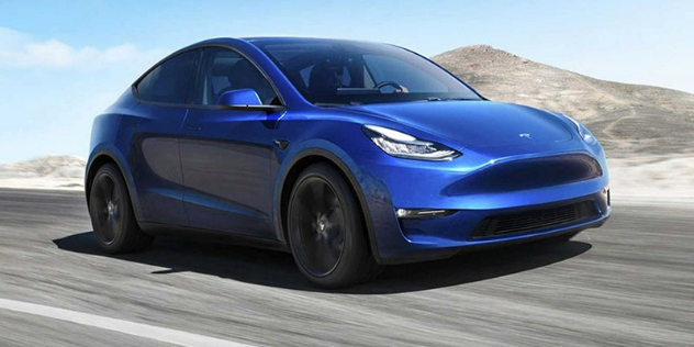 Side-angle view of a blue Tesla travelling very fast along a road.