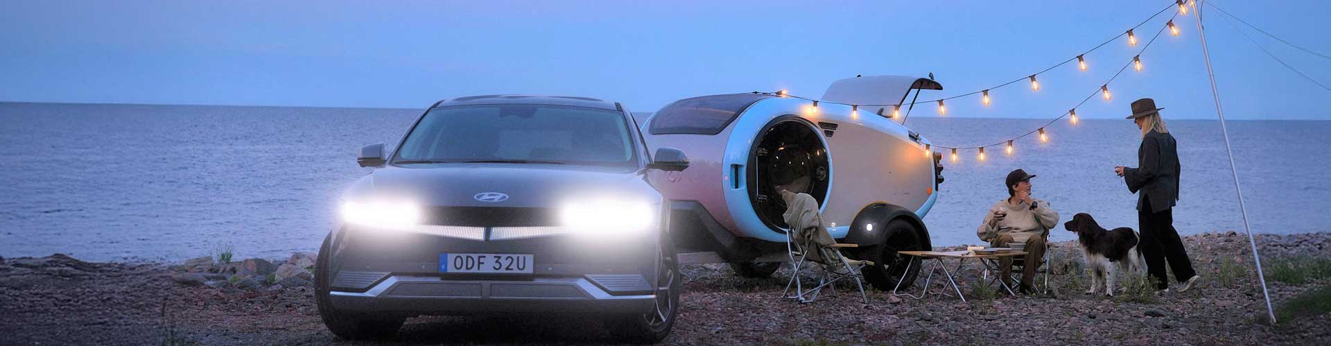 A family camping with their Hyundai Ioniq 5 powering fairy lights
