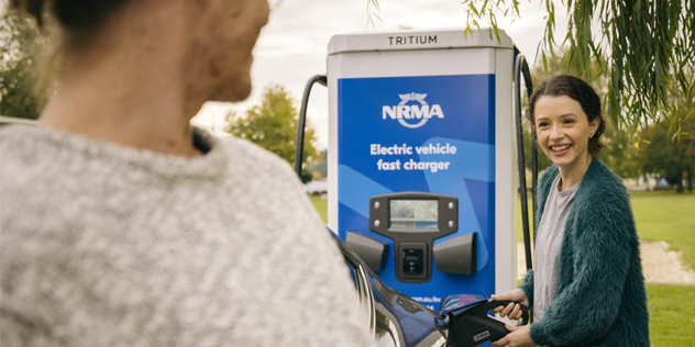 A child and their mother charging their EV at an NRMA charger