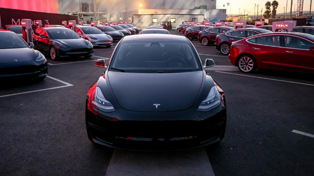 Front view of a black Tesla 3 sedan parked in a parking lot.