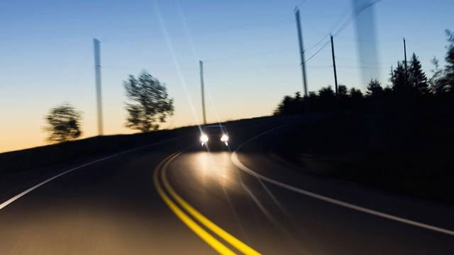  A oncoming car on a country road at dusk