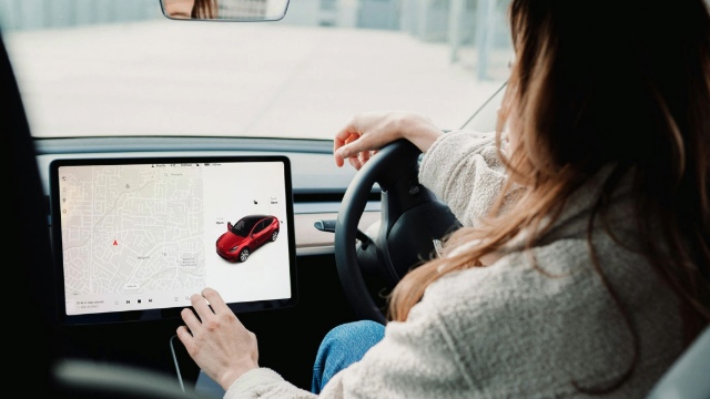 A driver using the touchscreen in their EV
