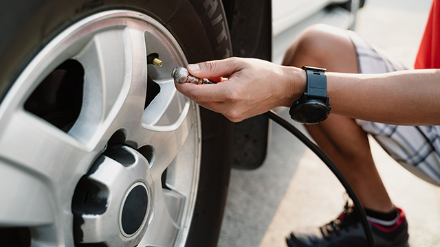 A man inflating a tyre with a tyre inflator 