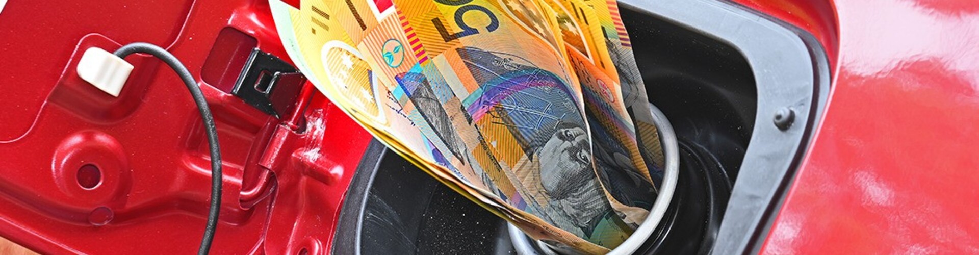 A wad of cash sticking out of a car's petrol tank filler