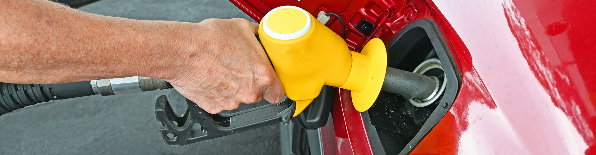 Man putting fuel into a red car