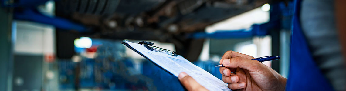 Mobile vehicle inspections Close-up side view of a man holding a clipboard and pen