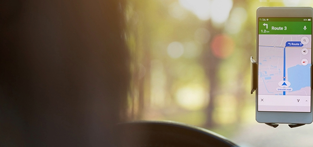 A mobile phone mounted on a car windscreen